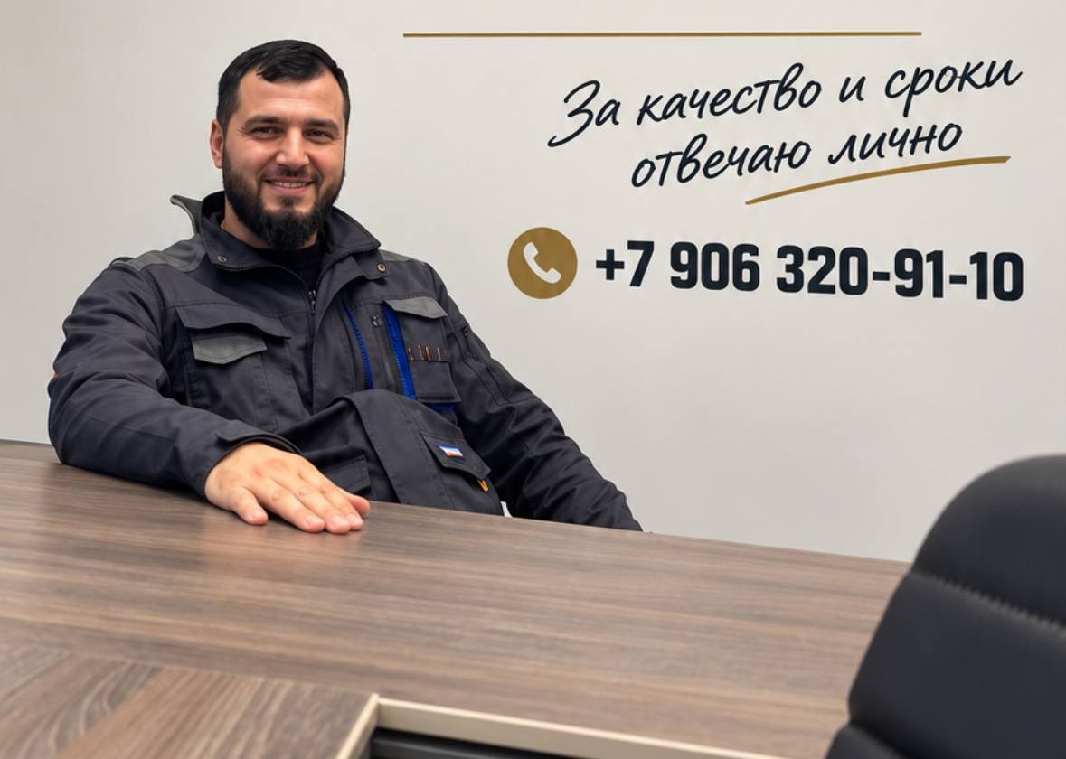 Ширхан за столом, на стене надпись «За качество и сроки отвечаю лично» и его телефон